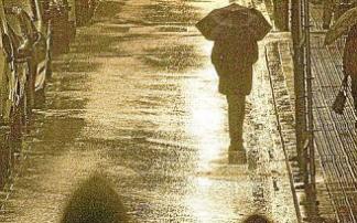 Dos jóvenes caminan por una calle de Bilbao en una noche lluviosa. Foto: Zigor Alkorta