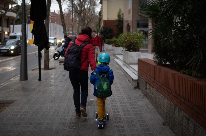 Una mujer acompaña a su hijo al colegio en Barcelona.