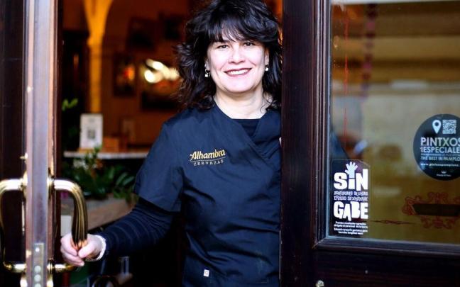 Natalia Ecay, propietaria de La Antigua Farmacia, junto al cartel anti agresiones pegado en la puerta del bar.