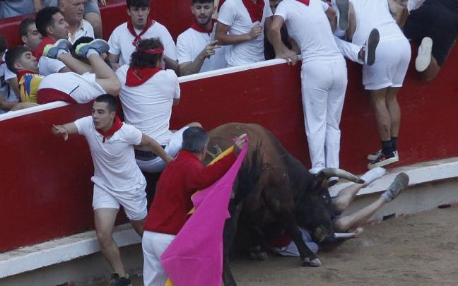 'Marismeño' embiste al joven donostiarra mientras el corredor australiano se sube a la barrera junto a su novia en el encierro del lunes.