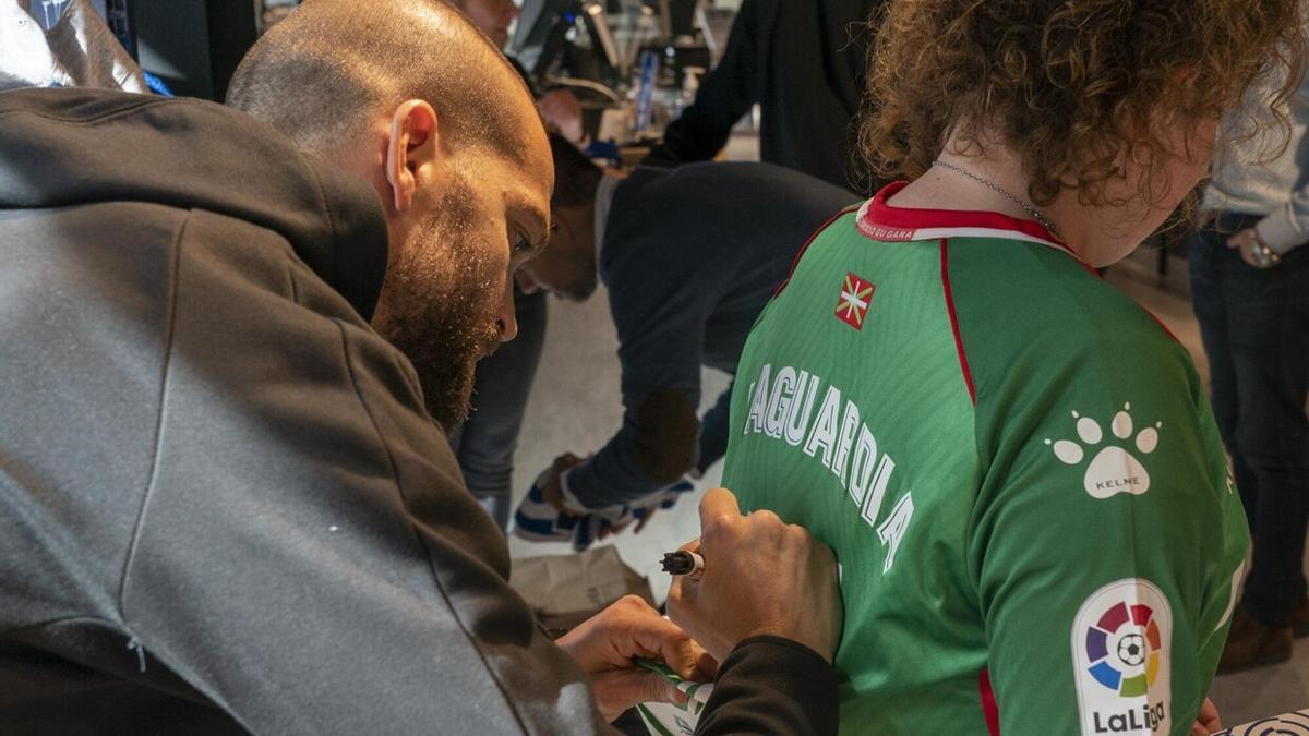 Víctor Laguardia firma una camiseta con su nombre a la espalda a una aficionada