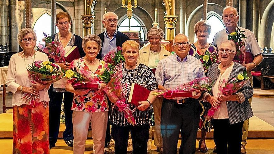 Foto grupal de los sis matrimonios que celebran sus bodas de oro y un matrimonio que celebra sus bodas de diamante.