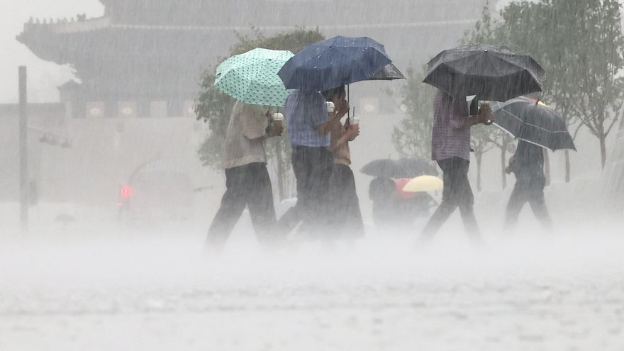 La gente camina bajo la lluvia a través de la Plaza Gwanghwamun en Seúl (Corea del Sur).