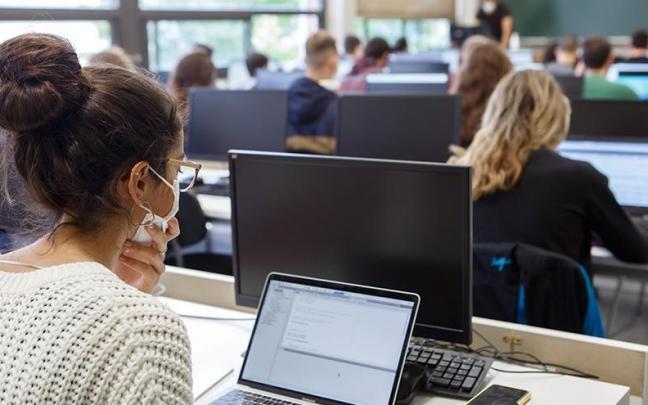 Estudiantes, con ordenadores, en clase.