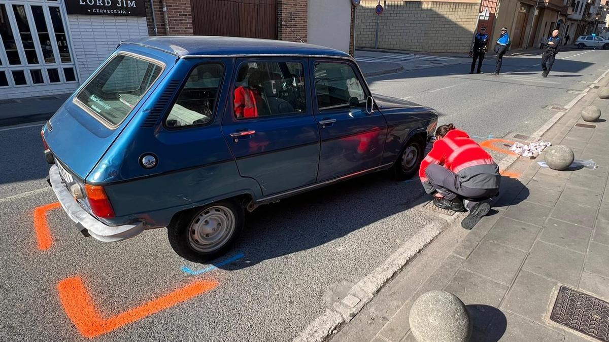 Un policía foral examina el turismo implicado en el atropello.