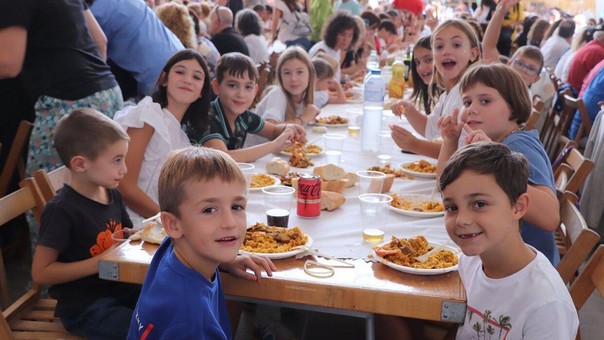 Un grupo de niños y niñas con sus platos de arroz.