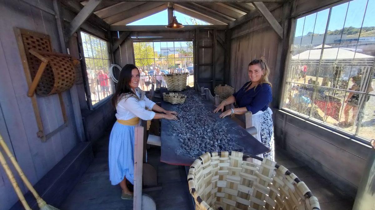 Dos jóvenes abantoarras emulan el duro trabajo de las txirteras en el lavadero de mineral instalado en esta edición en el espacio central de la Burdin Jaia.