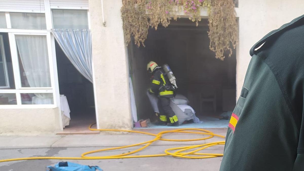 Bomberos y agentes de la Guardia Civil, en el lugar del incendio.