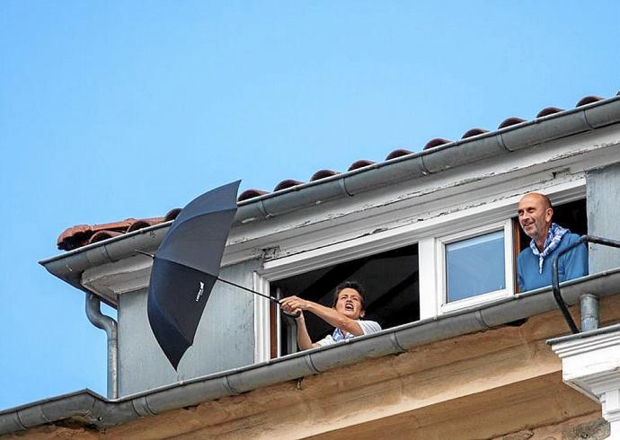 En el centro, imagen de una desértica y vallada Virgen Blanca. Arriba, la animada pareja que se atrevió a cantar desde uno de los edificios de viviendas de esta céntrica plaza y detalles del dispositivo policial. Fotos: Alex Larretxi / Jorge Muñoz / Pilar