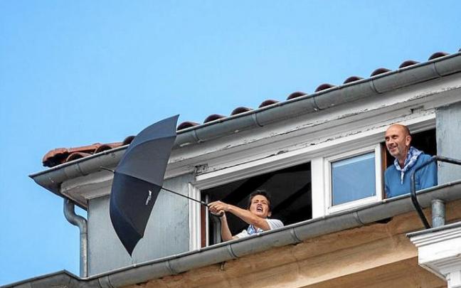 En el centro, imagen de una desértica y vallada Virgen Blanca. Arriba, la animada pareja que se atrevió a cantar desde uno de los edificios de viviendas de esta céntrica plaza y detalles del dispositivo policial. Fotos: Alex Larretxi / Jorge Muñoz / Pilar