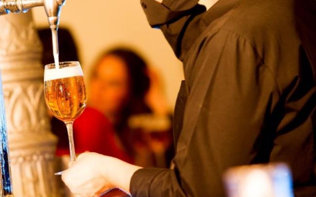 Un camarero sirviendo cerveza.