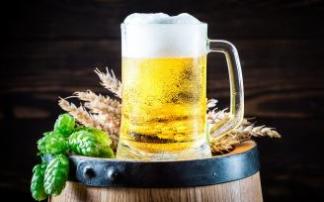 Una jarra de cerveza fresca y espumosa sobre un barril. Una jarra de cerveza fresca y espumosa sobre un barril.