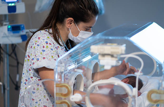 Una sanitaria atiende a un recién nacido.