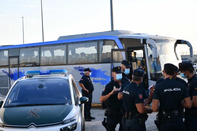 Policías y guardia civiles custodian a un grupo de menores marroquíes en Ceuta.