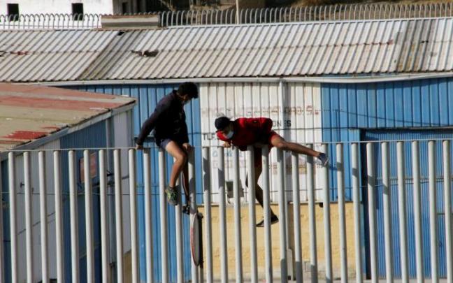 Dos jóvenes saltan la valla en Ceuta. Dos jóvenes saltan la valla en Ceuta.