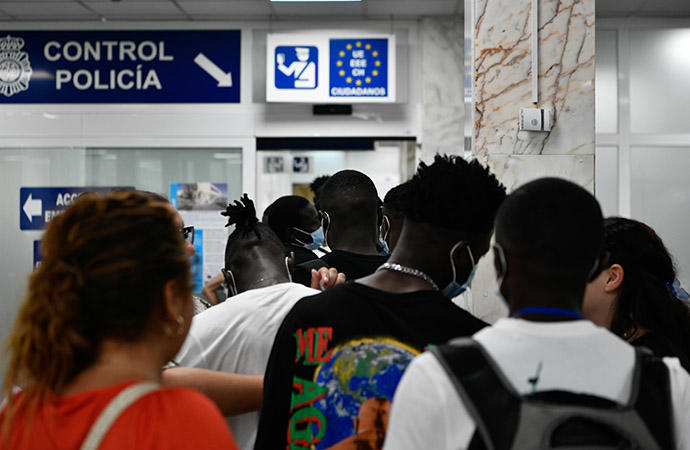 Varios migrantes hacen cola en el puerto de Ceuta para embarcar a la península.
