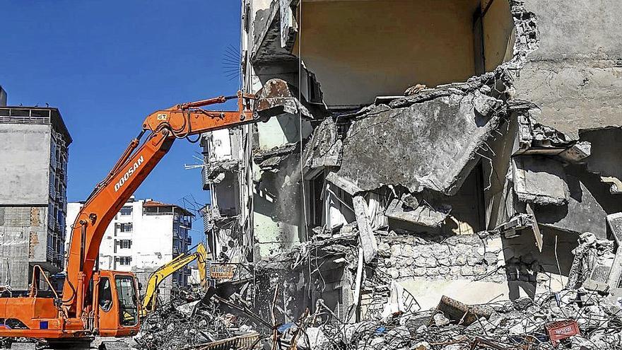 Las excavadoras proceden a derribar un edificio afectado en la ciudad turca de Samandag. | FOTO: EFE