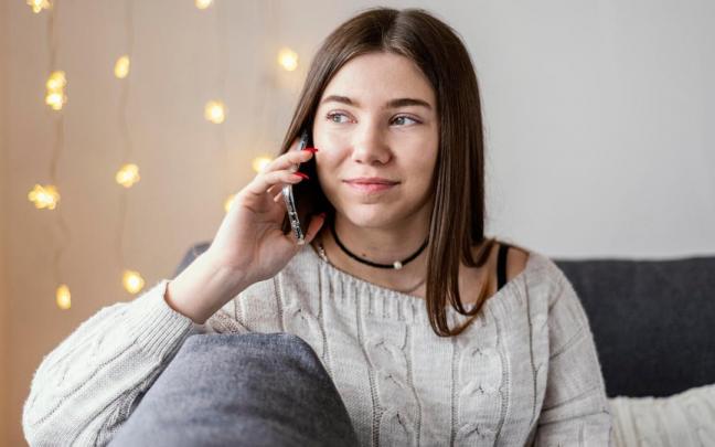 Una joven habla por su teléfono móvil Una joven habla por su teléfono móvil