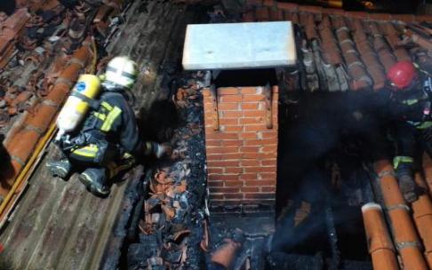 Bomberos en el tejado de la vivienda tras sofocar el incendio