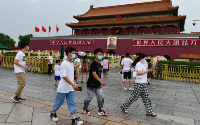 Varias personas caminan por las calles de Beijing.