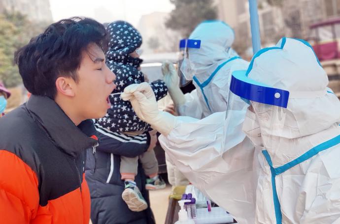 Un sanitario realiza un test covid en China