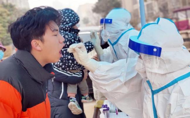 Un sanitario realiza un test covid en China Un sanitario realiza un test covid en China