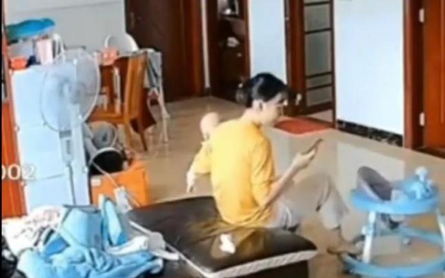 La mujer, meciendo el andador vacío mientras sostiene al bebé en su brazo. La mujer, meciendo el andador vacío mientras sostiene al bebé en su brazo.