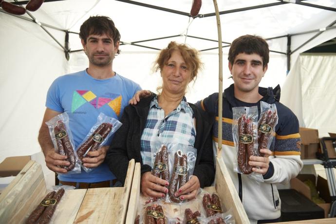 Anxo, Maite e Indar, madre e hijos en su puesto de la Feria del Producto Local, en la Plaza del Castillo.