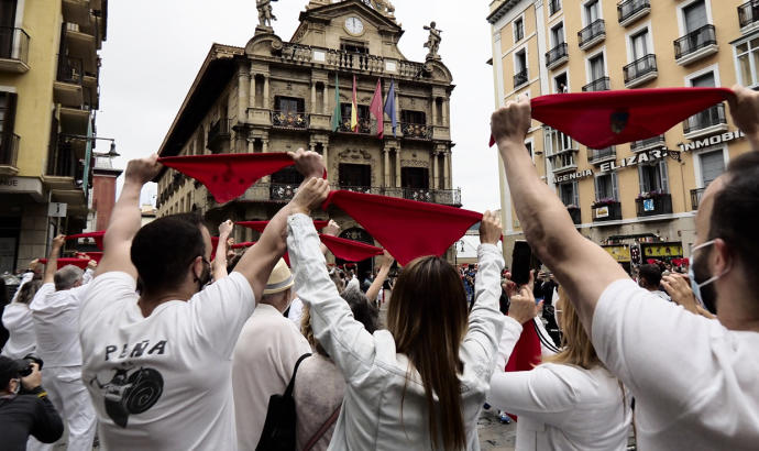 Varias personas levantan los pañuelos rojos a las 12 del mediodía el 6 de julio de 2021.