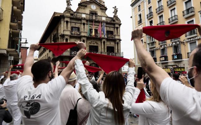 Varias personas levantan los pañuelos rojos a las 12 del mediodía el 6 de julio de 2021.