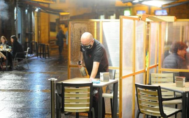 Un trabajador de hostelería recoge una terraza