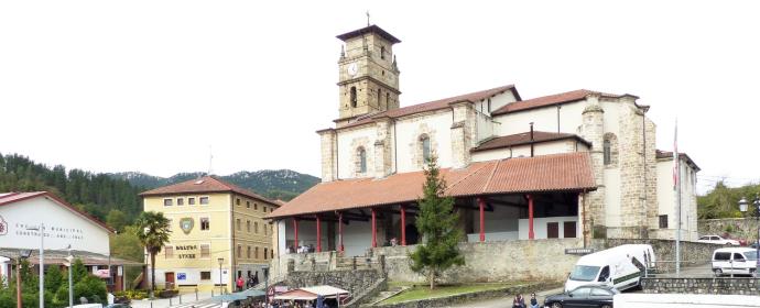 La iglesia se yergue tras la plaza de toros situada en el centro del municipio, en la imagen, llena de toldos de los puestos de venta de queso en el Gazta Eguna.