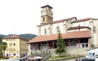 La iglesia se yergue tras la plaza de toros situada en el centro del municipio, en la imagen, llena de toldos de los puestos de venta de queso en el Gazta Eguna.