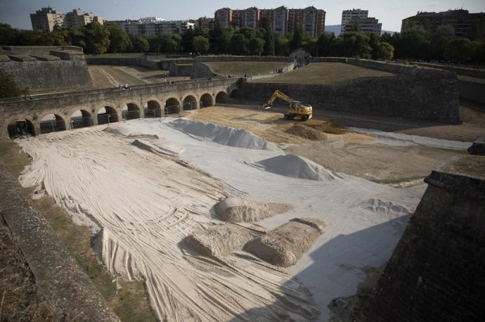 Las excavadoras echando arena en los fosos de la Ciudadela.