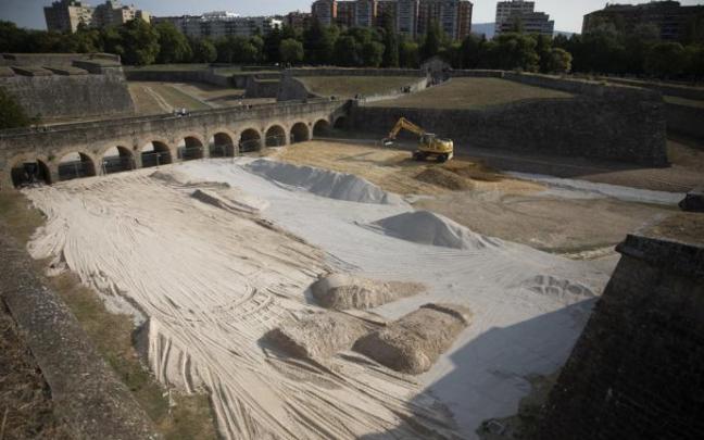 Las excavadoras echando arena en los fosos de la Ciudadela.
