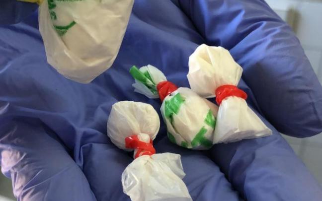 Un policía muestra varias bolsitas con cocaína. Un policía muestra varias bolsitas con cocaína.