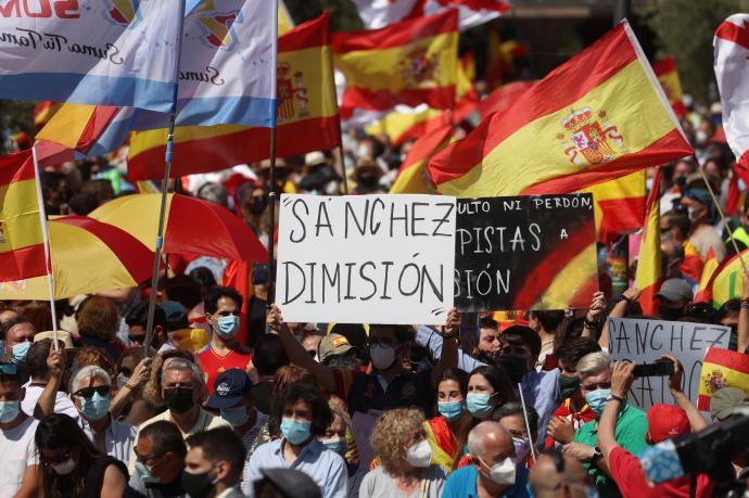 Manifestantes ondean banderas españolas mientras asisten a la concentración convocada por la plataforma Unión 78
