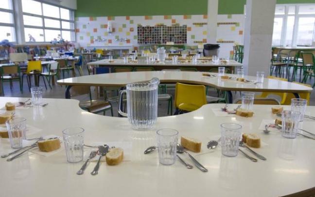 Un comedor escolar con las mesas preparadas.
