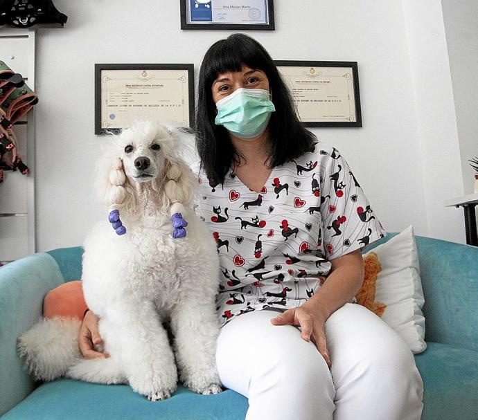 Sel, una caniche que ha ganado varios concursos, posando con su propietaria, Ana Mesón, en su peluquería canina de Vitoria