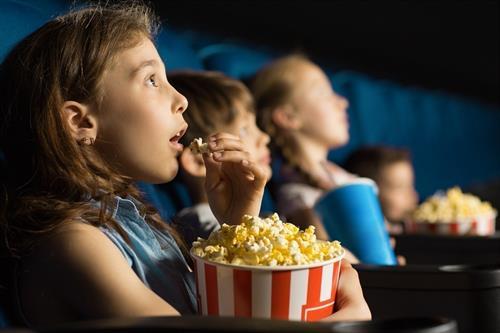 Niños comiendo palomitas en un cine