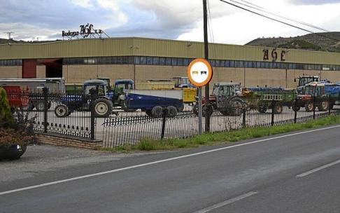Una fila de tractores espera a la entrada de una bodega para descargar las uvas de sus remolques. Una fila de tractores espera a la entrada de una bodega para descargar las uvas de sus remolques.