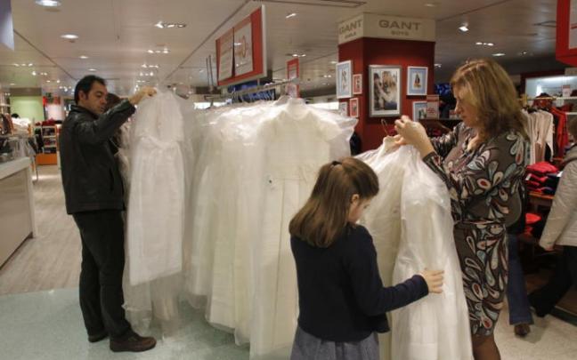 Clientes miran vestidos de primera comunión. Clientes miran vestidos de primera comunión.