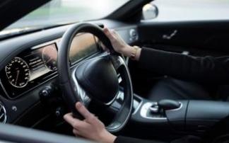 Un conductor maneja el volante con las dos manos. Un conductor maneja el volante con las dos manos.