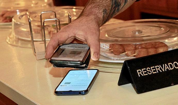 Leyendo un pasaporte covid en un local hostelero de Gasteiz. Foto: Pilar Barco
