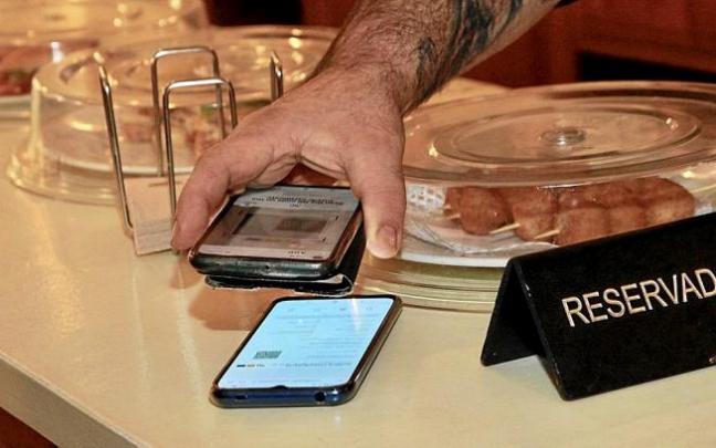 Leyendo un pasaporte covid en un local hostelero de Gasteiz. Foto: Pilar Barco