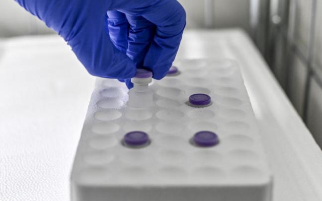 Personal médico recoge dosis de vacunas de un congelador.