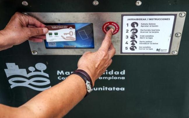Una usuaria acciona el sistema del contenedor de apertura con tarjeta electrónica. Una usuaria acciona el sistema del contenedor de apertura con tarjeta electrónica.
