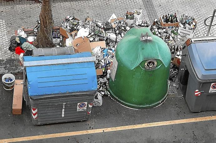 Contenedores rodeados de botellas de vidrio el pasado domingo al mediodía en la calle Autonomía. Fotos: N.G.