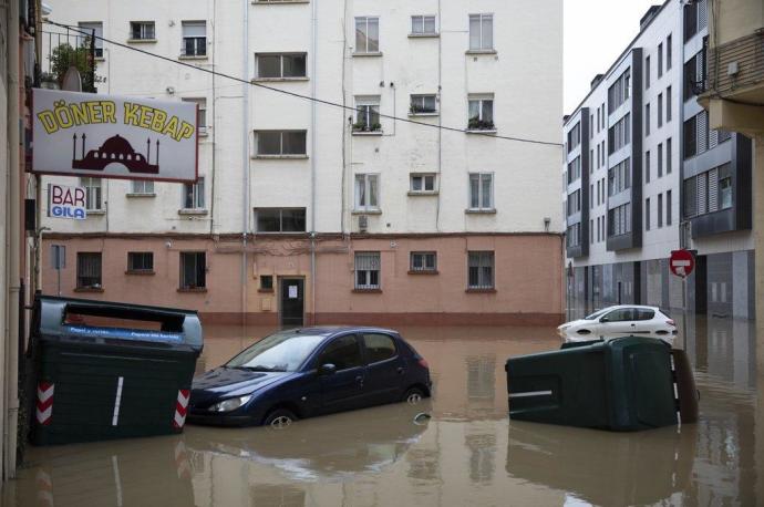 Contenedores flotando arrastrados por la riada en Villava-Atarrabia.