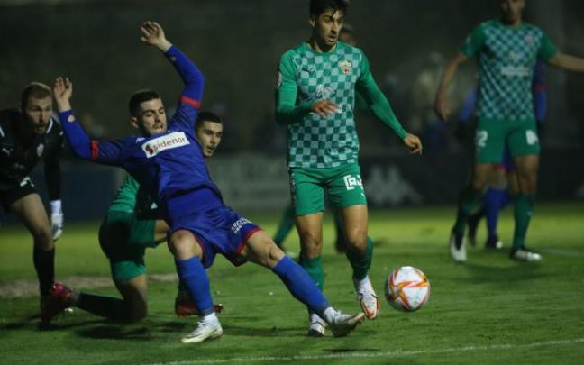 Iker Unueta disputa un balón ante la defensa del Almería